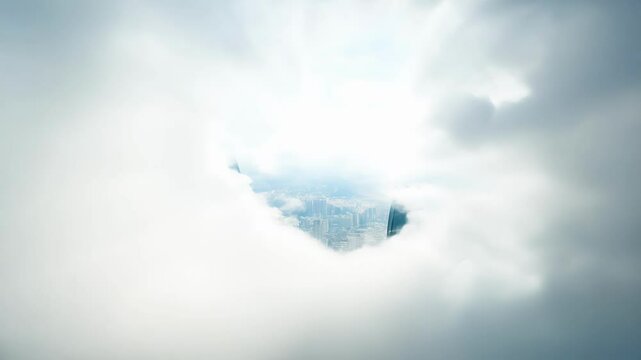 Flying through a thick layer of clouds FPV hyperspeed unveils a breathtaking view of the city skyline.