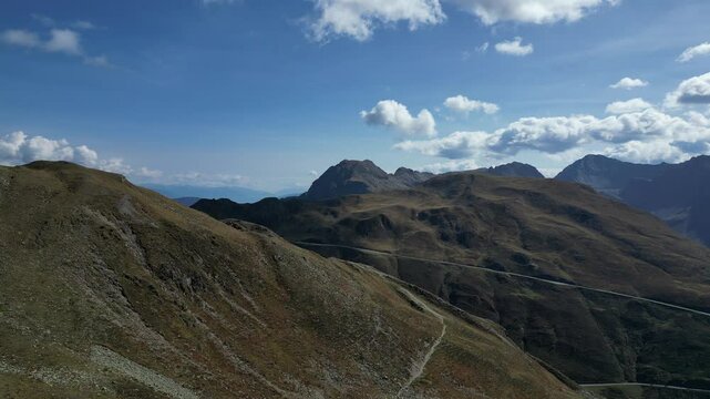 Luftaufnahme des Penser Jochs im Herbst bei Sonnenschein mit ein paar Wolken