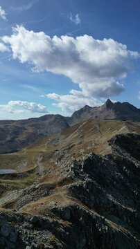 Luftaufnahme des Penser Jochs im Herbst bei Sonnenschein mit ein paar Wolken