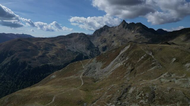 Luftaufnahme des Penser Jochs im Herbst bei Sonnenschein mit ein paar Wolken