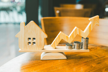 Wood house, up arrow and row of coin money on wood table and , selective focus, Planning to buy property. Choose what's the best. A symbol for construction ,ecology, loan concepts.	