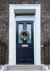 Victorian Door in London, England with a Traditional Christmas Wreath and Railings.