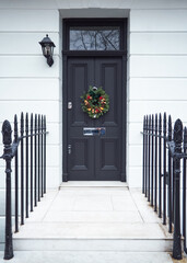 Victorian Door in London, England with a Traditional Christmas Wreath and Railings.