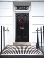 Victorian Door in London, England with a Traditional Christmas Wreath and Railings.