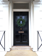 Victorian Door in London, England with a Traditional Christmas Wreath and Railings.