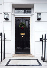 Victorian Door in London, England with a Traditional Christmas Wreath and Railings.
