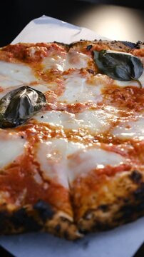 Close-up, Margherita pizza with melted mozzarella cheese spinning in a circle. Vertical video. Fresh delicious food. Pizza Margherita. Italian Cuisine.