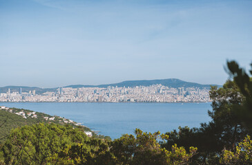Obraz premium View of Istanbul skyline from Buyukada Island, with the sea and greenery in the foreground, under a blue sky