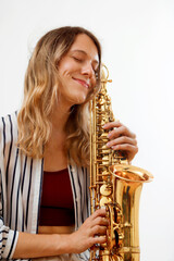 Fototapeta premium Casual blonde girl hugging her saxophone