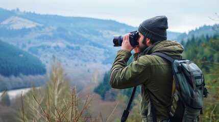 photographer with camera and tripod taking pictures of mountain landscape