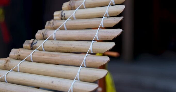 musical instrument tubes chinese. bamboo wind chime hanging on the house wall in the backyard