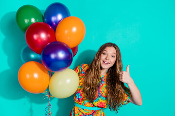 Obraz premium Photo portrait of lovely teen lady thumb up approve air balloons dressed stylish colorful garment isolated on cyan color background
