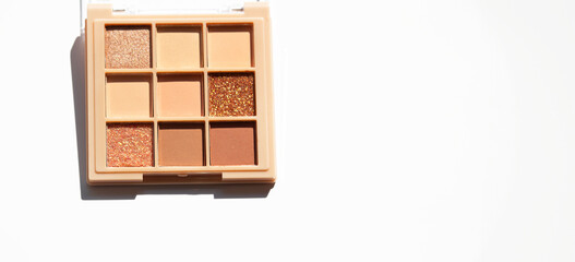 Makeup palette on white. Professional makeup eyeshadow palette in beige and brown shades.