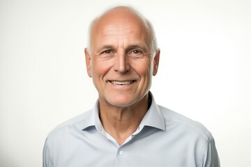 Obraz premium A man with a white shirt and gray hair is smiling. He looks happy and content. Concept of warmth and positivity