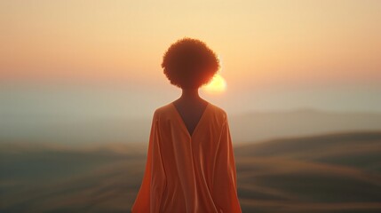 Fototapeta premium Woman in an orange dress peacefully gazes at a stunning sunset over a misty valley, feeling inspired by the beauty of nature