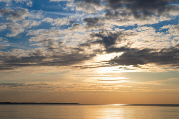 Sunset over the sea. Reflection of sunlight in the sea waves. The sky in the sunset rays. Baltic Sea.