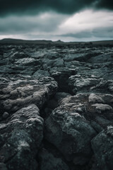Obraz premium Desolate Rocky Terrain Under Ominous Cloudy Sky