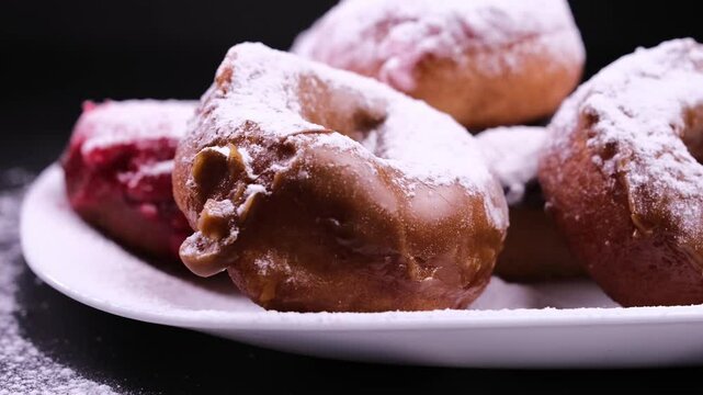sprinkle donuts with powdered sugar on a black background