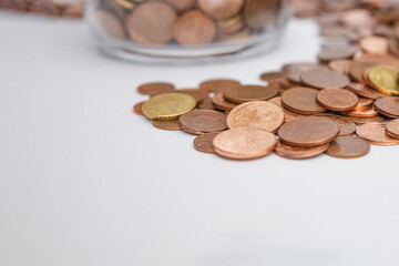 a lot of coins on the table o the white background with a space for lettering