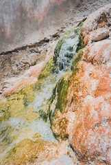 Mineral hot spring Garm Chashma paints rocks in different colors in Tajikistan in Pamir