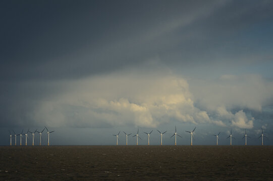 View of Gunfleet sands offshore windfarm against a stormy sky taken from the shore of Clacton on sea, Essex, UK.