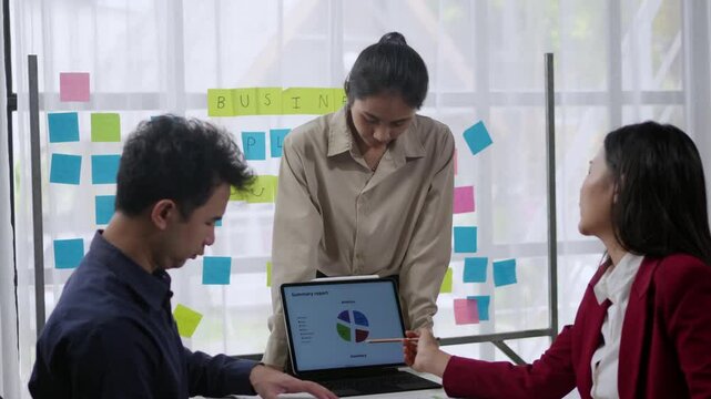 Business colleagues analyzing data on laptop during team meeting. Engaged in collaborative project planning in office settings