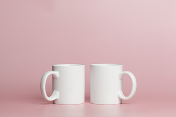 white cups for tea or coffee on a pink background