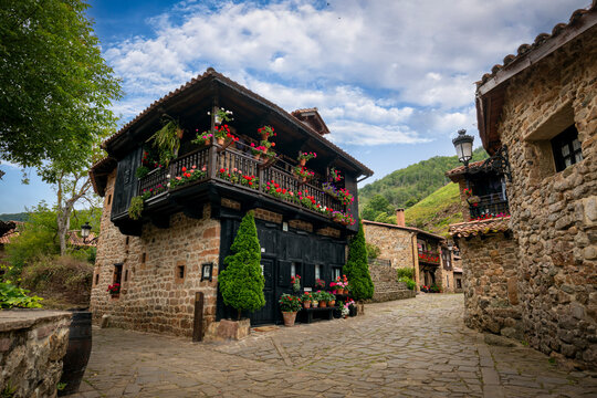 Typical street of the medieval town of B&aacute;rcena Mayor, Cantabria, Spain, with flowers on its wooden balconies and stone paving
