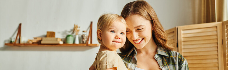 A young mother tenderly holds her toddler daughter in her arms, sharing a precious moment of love and connection at home.