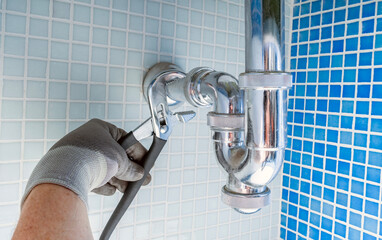 Plumber clearing or unclogging the clogged sink drain siphon. Plumbing and troubleshooting. Home...