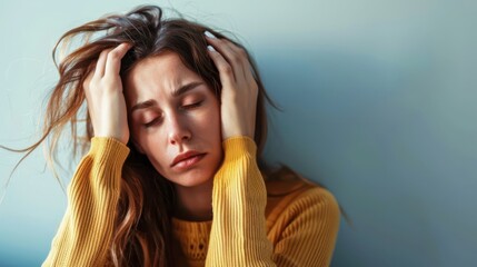 Woman With Messy Hair Holding Her Head in a Yellow Sweater