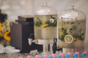 Lemonade jar on wooden table outdoors. Rustic catering at wedding reception. Cocktail bar. Cold drinks, lemonade from natural fruits on the buffet. Catering, service, aperitif.