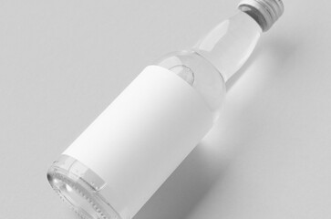 Miniature spirits, liquor bottle mockup. Clear glass and liquid with a blank label.