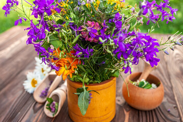 A Bouquet of Wildflowers in a Yellow Pot on a Wooden Table