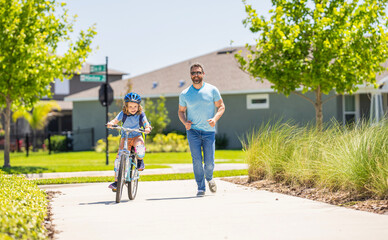 Obraz premium fatherhood of father and son cycling at sunlit park. creating lasting memories. father and son navigate winding paths together at fatherhood. father and son promenade. father and son in fatherhood