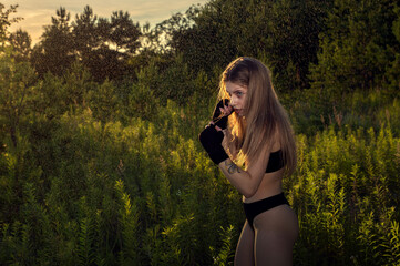 Young woman in a boxing stance in an open space.