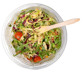 Salad in a plastic transparent container along with a wooden fork on an isolated background.