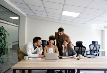 Multiethnic colleagues standing around the laptop. Finishing important job