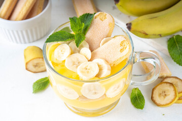 Banana Pudding Dessert on Glass cup. Layered parfait dessert with cookies and banana slices, copy space