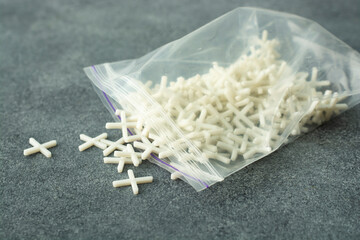 White crosses used for laying gres tiles. Accessories and tools needed for construction workers.