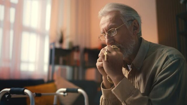 Religious senior man with praying beads asking God for health, saying prayer