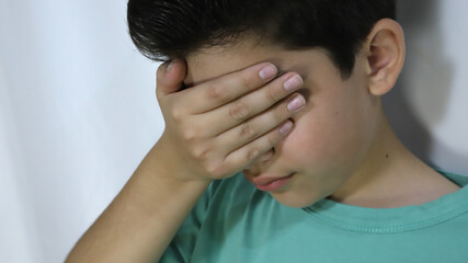 Children playing hide and seek in the park. Boy blindfolded and counting while playing hide and seek. Classic children's game.