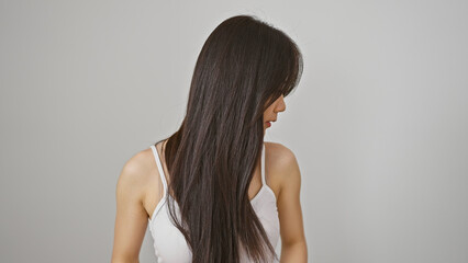 Obraz premium Profile view of a young asian woman with long hair against a white background, exuding elegance and simplicity.