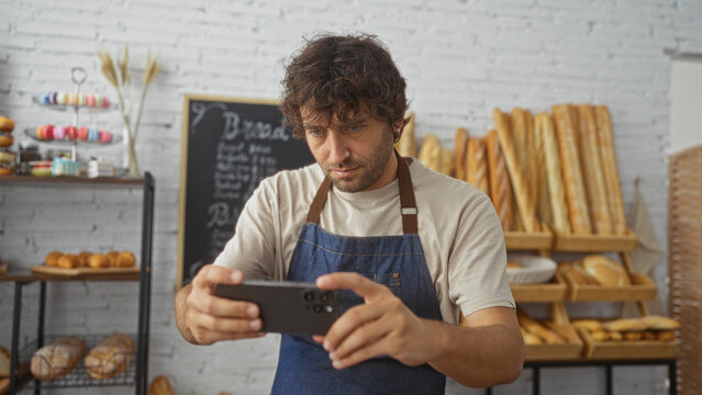 Young man taking photo in bakery with fresh bread and pastries in the background