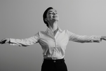 A woman in a crisp white shirt, eyes closed, arms outstretched, stands against a plain background, radiating an aura of contentment and newfound freedom