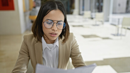 Focused young woman working at bright modern office