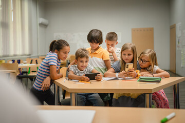 Young students use cellphone for video games on a break at school