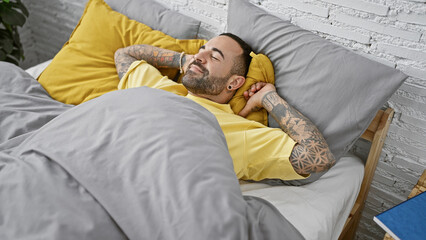 Handsome tattooed hispanic man resting peacefully in a cozy bedroom, conveying serenity and home comfort.