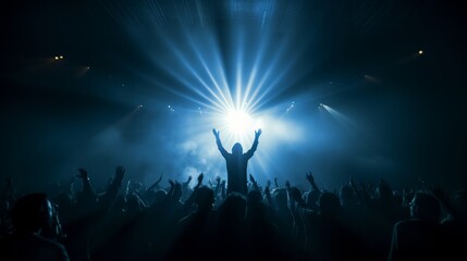Energetic silhouetted concert crowd with raised hands in expressive blue stage light ambiance