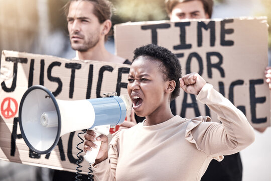 Frustrated black woman, megaphone and protest with crowd for human rights, equality or change in society or city. Angry African, female person or activist screaming on loudspeaker in riot or rally